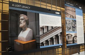 An image board in an exhibition showing a bust of Alexander Greek Thomson.