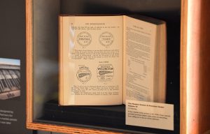 An old book called The Modern Grocer in a glass exhibition display cabinet