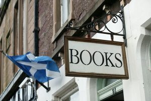 A traditional sign with the word 'books' on it, hanging outside a Scottish book store