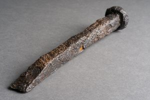 An ancient mason's chisel on top of a grey table