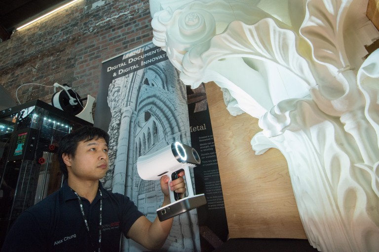 Someone holding up a scanner to a piece of stone