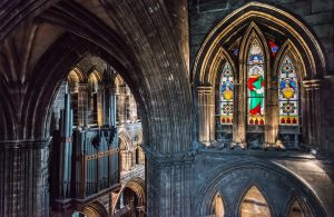 A look inside Glasgow Cathedral featuring a stained glass window and organ