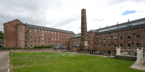 A large, industrial building with a huge chimney