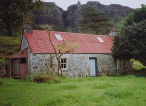 A building in the countryside made from stone with a corrugated iron roof