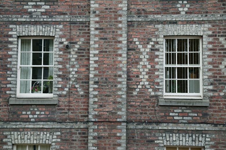 A brick building with red bricks and a pattern of white bricks around the windows