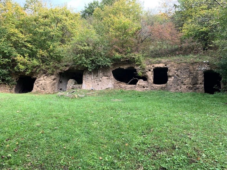 Five caves, surrounded by grass and trees