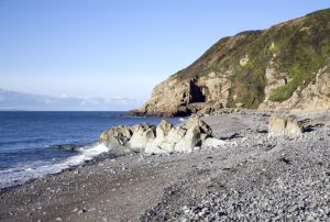 A cave on the coast with a stone beach