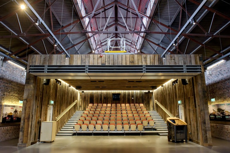 A large, open auditorium clad with wood