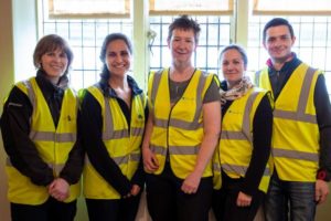 A group of people standing together, wearing high-vis vests