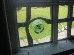 A glass, panelled window, with a bubble at the centre of the pane