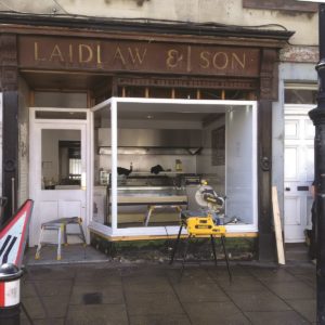 Very old, faded text on a shopfront sign