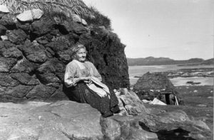 A crofter women sitting outside her croft