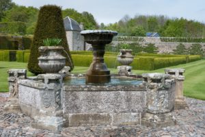 A large iron fountain with stone surround in a historic garden