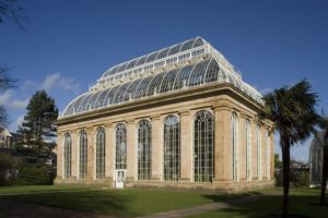 A large, stone and glass glasshouse