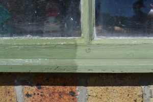 A wooden window frame painted green