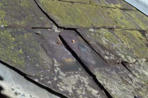 Damaged roof slates, covered with moss