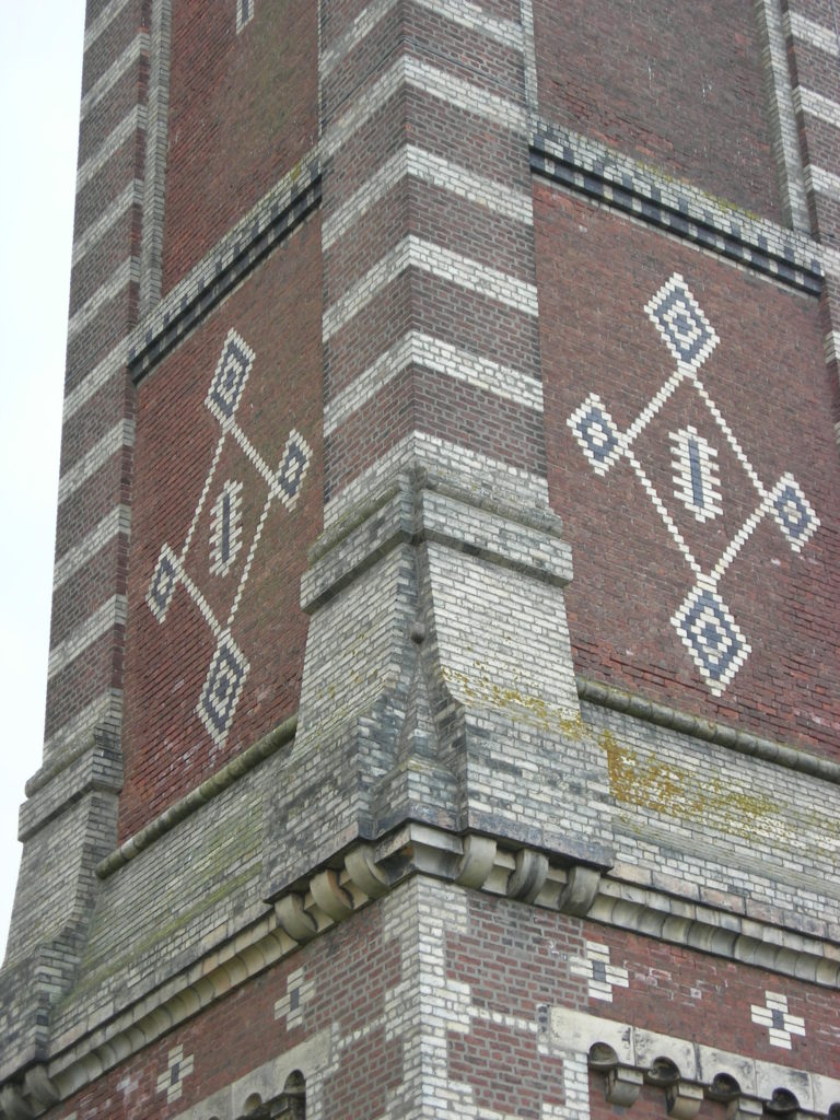 A tall brick stack, with designs and patterns made from brick designed into the building
