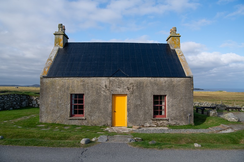 A historic cottage in the middle of nowhere with a bright yellow door