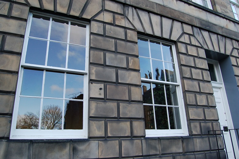 Two large sash and case windows on a stone ashlar building