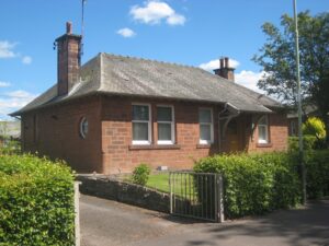 A red sandstone bungalow with a slate roof