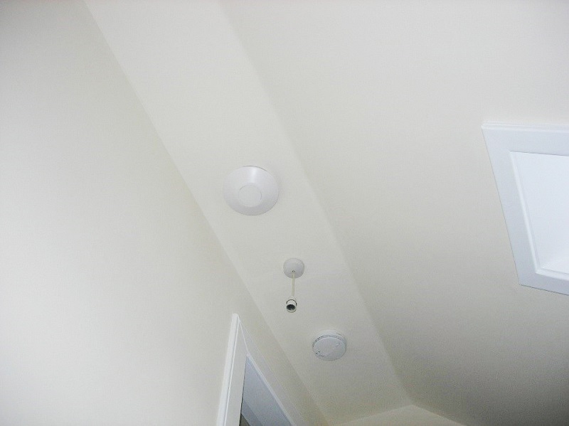 A ceiling with a device installed into it that looks like a smoke detector