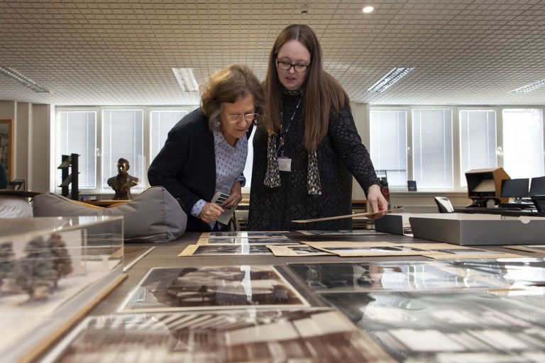 Two people looking at archive images in a cabinet