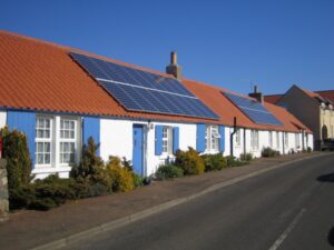 Rows of solar panels on the orange pantile roof of a historic cottage