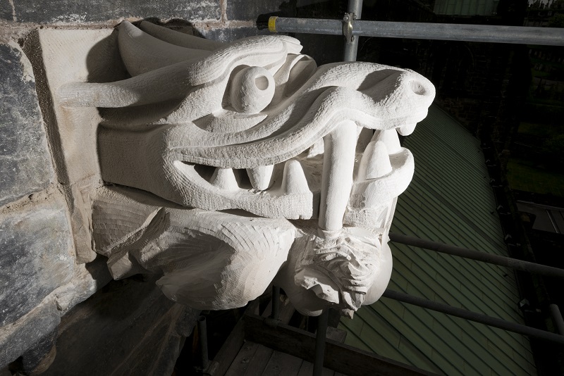 A wyvern (type of dragon) carved into the side of a building as a stone gargoyle