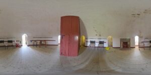 A 360 degree photograph of the interior of a tower, with a wooden floor and chairs around the edge of the wall.