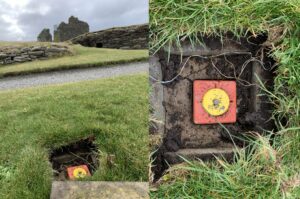 A composite image of a survey marker in the ground at a historic site. The marker is a red square of plastic with a yellow circle on top, and it is sitting in a square hole in the grass next to a gravel path.