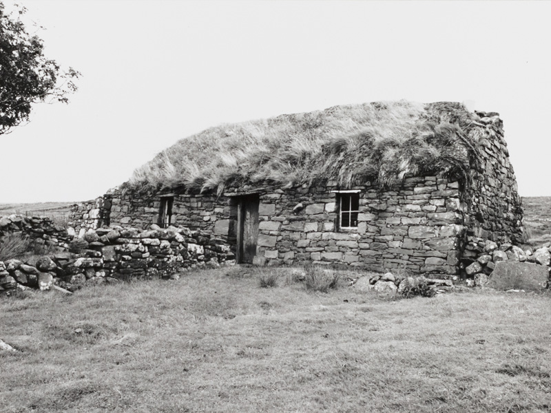 An old stone cottage in the rural countryside with a thatched roof