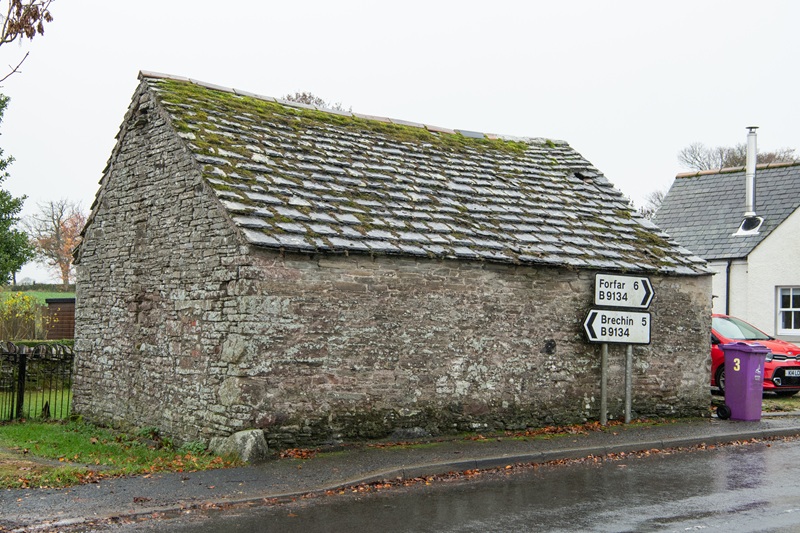 A stone, single-storey building with a mossy flagstone roof