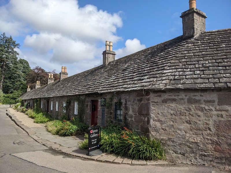 A row of lovely, well-kept traditional stone cottages with a flagstone roof