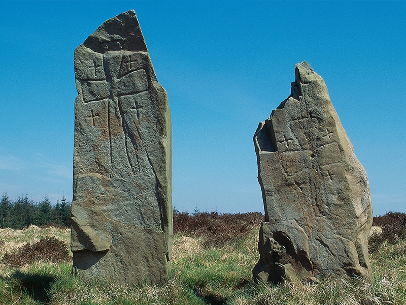 Two standing stones, side by side, carved with a large cross on each and several smaller crosses